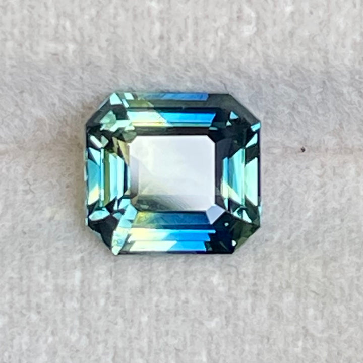 Natural 2.08 carat parti sapphire from Madagascar, cushion cut, unheated with a clean appearance, measuring 7.3 × 6.3 × 4.0 mm, loose earth-mined gemstone by Crystal Gem &amp; Jewelry.