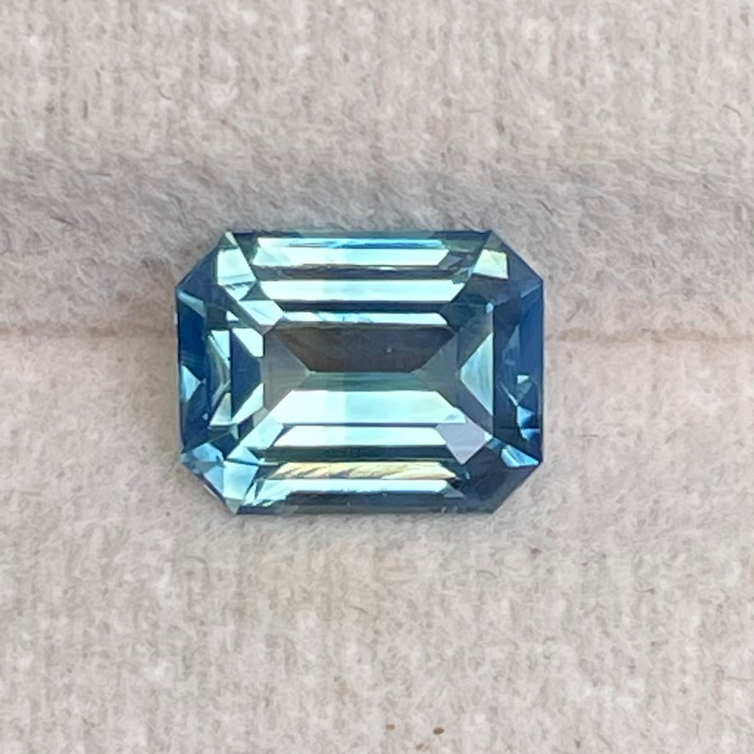 Natural 2.06 carat teal sapphire from Madagascar, emerald cut, unheated with a clean appearance, measuring 7.8 × 6 × 4.3 mm, loose earth-mined gemstone by Crystal Gem & Jewelry.