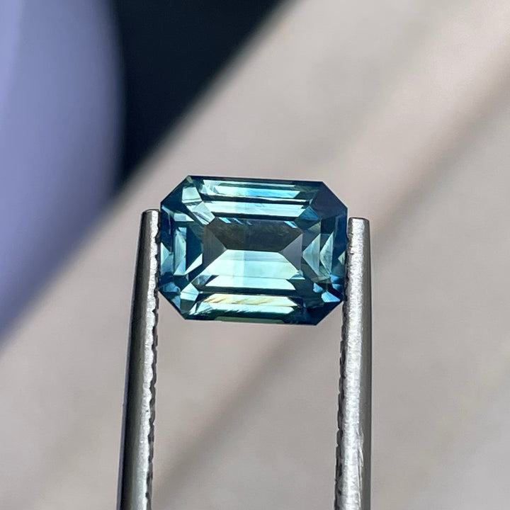 Natural 2.06 carat teal sapphire from Madagascar, emerald cut, unheated with a clean appearance, measuring 7.8 × 6 × 4.3 mm, loose earth-mined gemstone by Crystal Gem &amp; Jewelry.