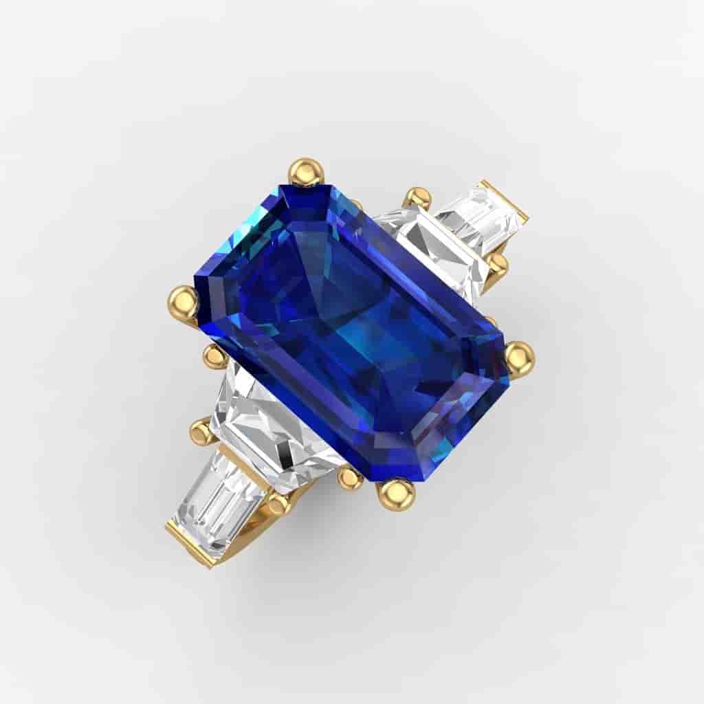 Emerald cut blue sapphire ring set in yellow gold with baguette diamond side stones on a light grey background